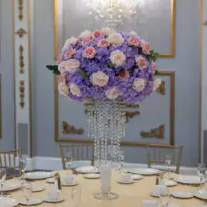 Luxurious floral centerpiece with purple hydrangeas and pink roses at an elegant wedding reception.