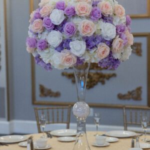 Vibrant floral centerpiece with pastel roses and purple hydrangeas for elegant event decor.