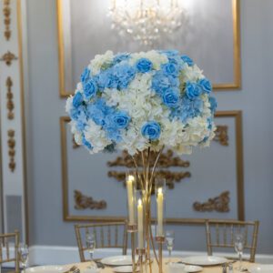 Elegant floral centerpiece with blue and white roses and hydrangeas at an upscale event.