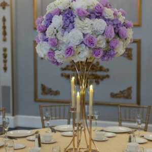 Elegant floral centerpiece with purple and white roses for wedding decor.