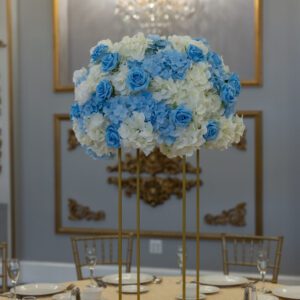 Elegant floral centerpiece with blue and white roses for wedding or event decor.