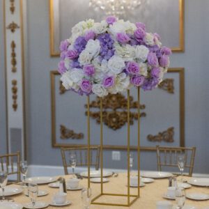 Elegant floral centerpiece with white, lavender, and purple roses at a luxury event.