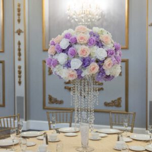 Elegant floral centerpiece with roses and hydrangeas at wedding reception.