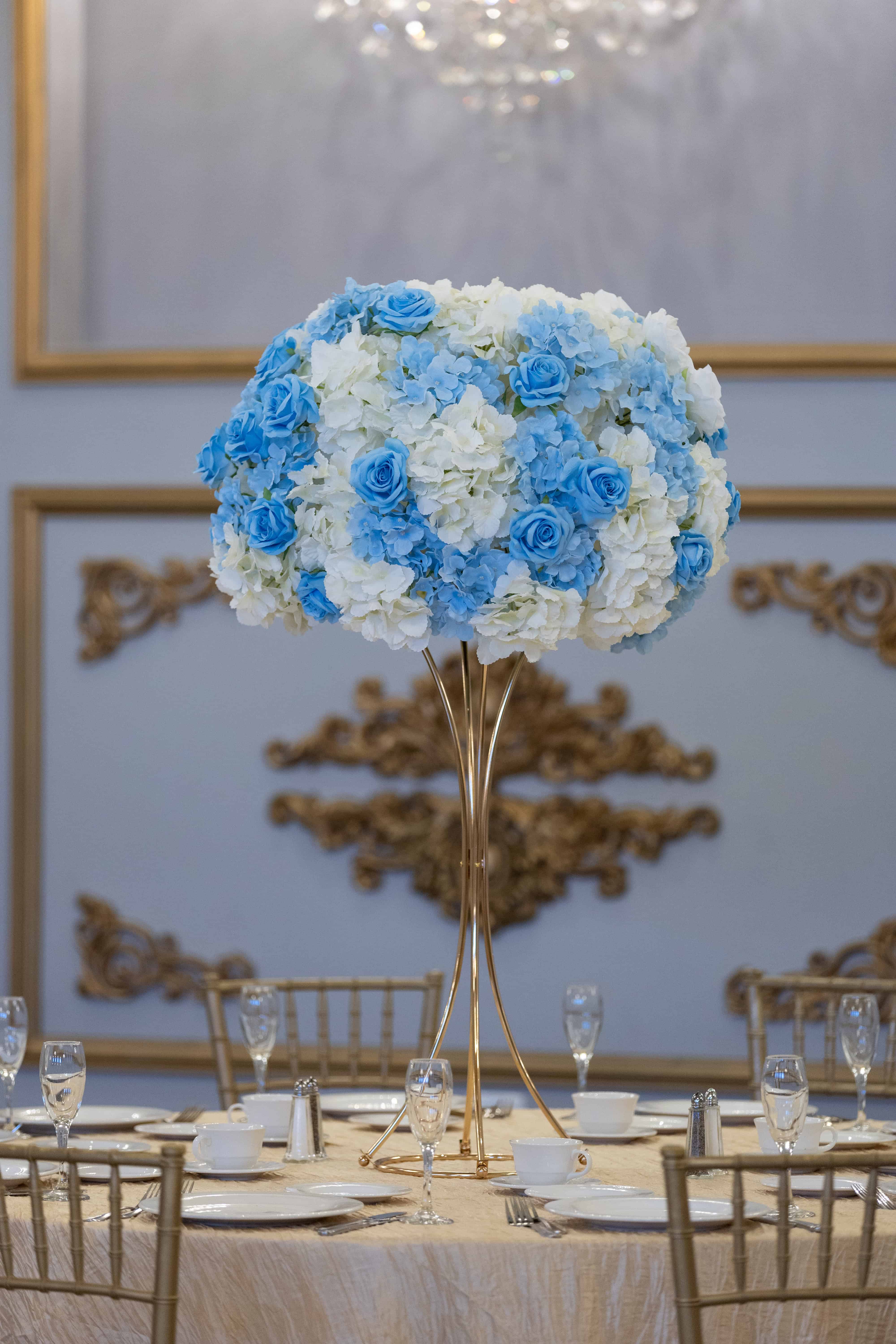Luxurious floral centerpiece with blue and white hydrangeas and roses for elegant event decor.